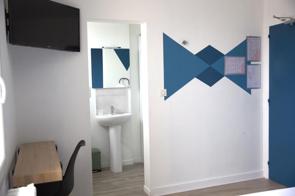 La salle de bains est pourvue d'un lavabo et d'une télévision murale. dans l'établissement RELAIS 375, à Couhé-Verac
