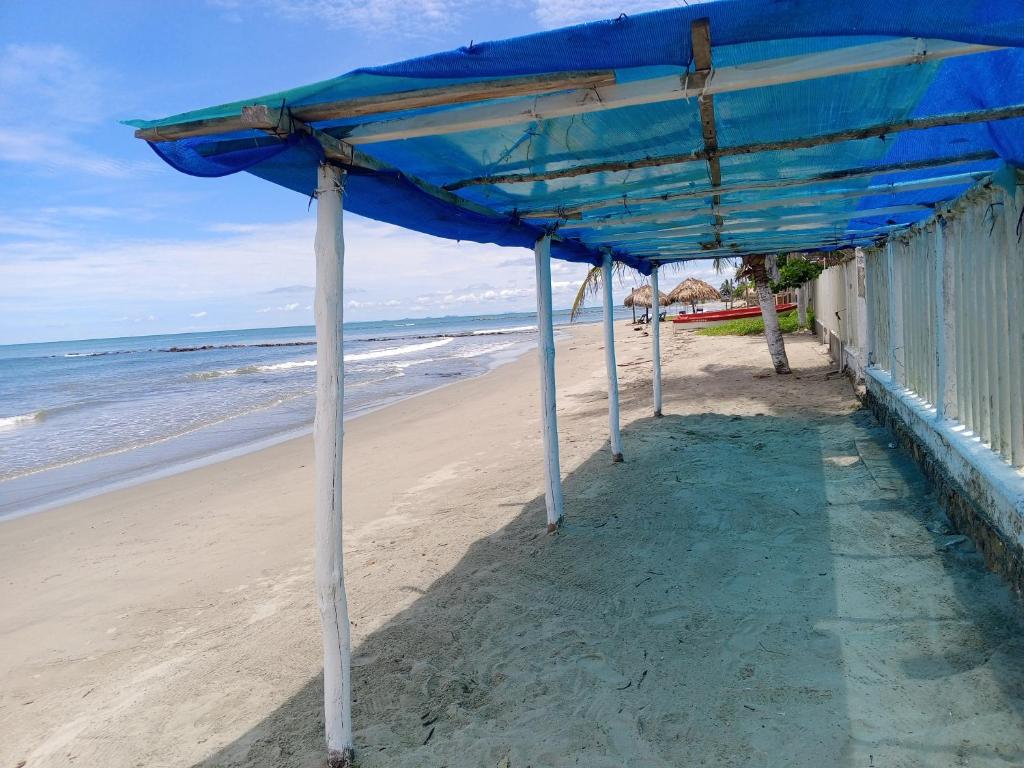 una sombrilla azul en una playa junto al océano en Mary playas coveñas, en Coveñas