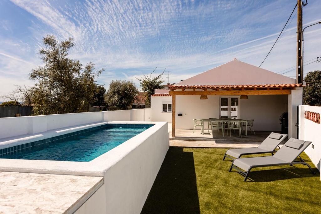 a backyard with a swimming pool and a house at Country Pool House 27 in Abrantes