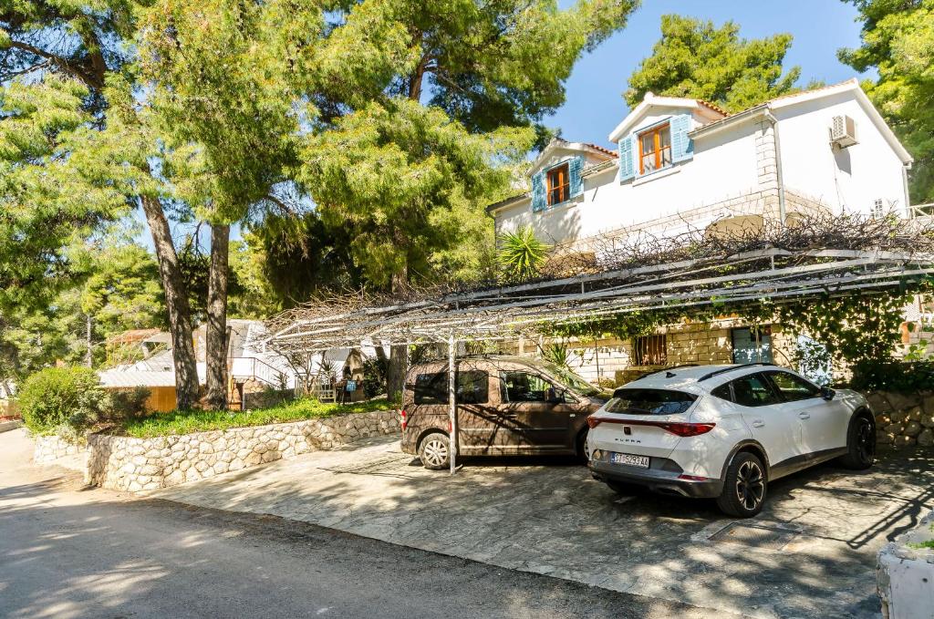 two cars parked in front of a house at Apartments Verdun in Ivan Dolac