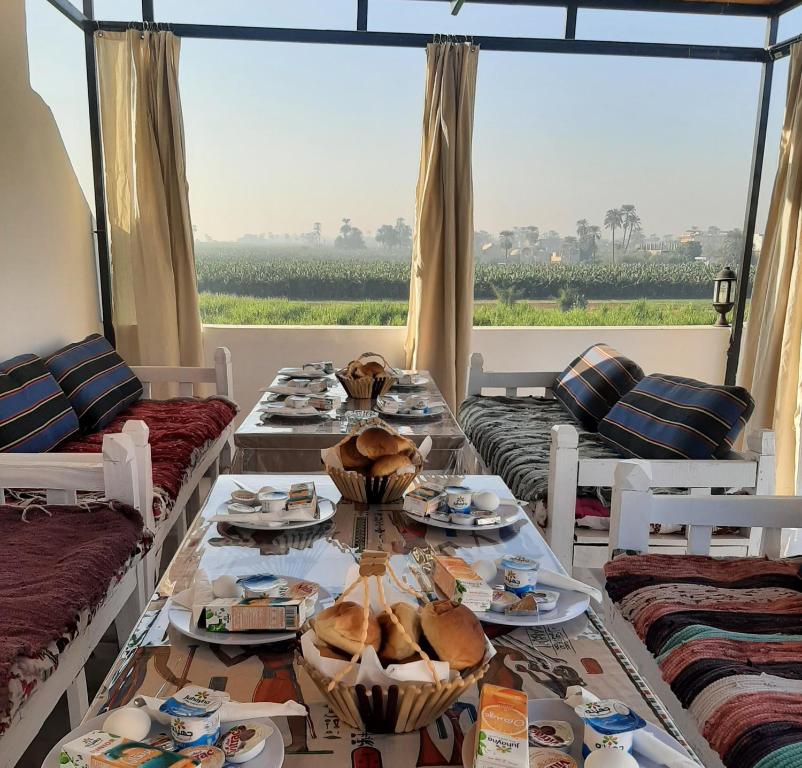 Panorama Hotel في الأقصر: غرفة طعام مع طاولة مع أطباق من الطعام