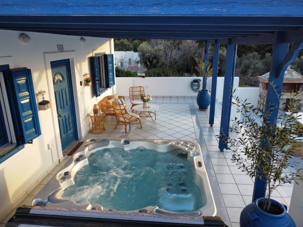 a hot tub on the patio of a house at Giannis & Maria Sunset House in Lagoúdi Zía