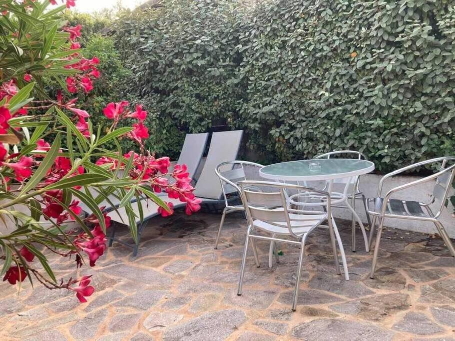 - une terrasse avec une table, des chaises et des fleurs dans l'établissement Studio à 200m du centre ville de Porto Vecchio., à Porto-Vecchio