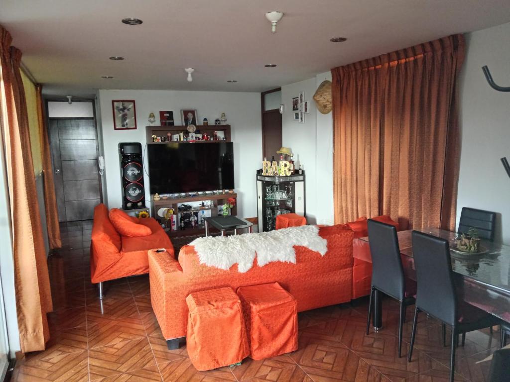 a living room with an orange couch and a table at Yanahuara apartaments in Arequipa