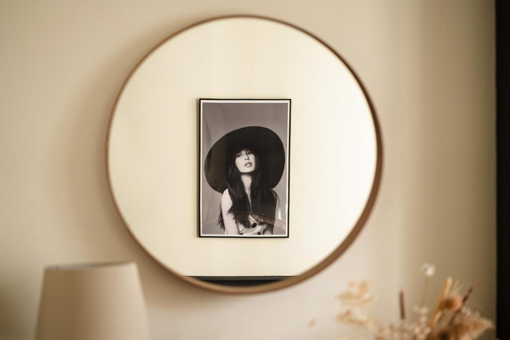 a mirror on a wall with a picture of a woman at L&#39;Orée du Faubourg - VENDOME CENTRE in Vendôme