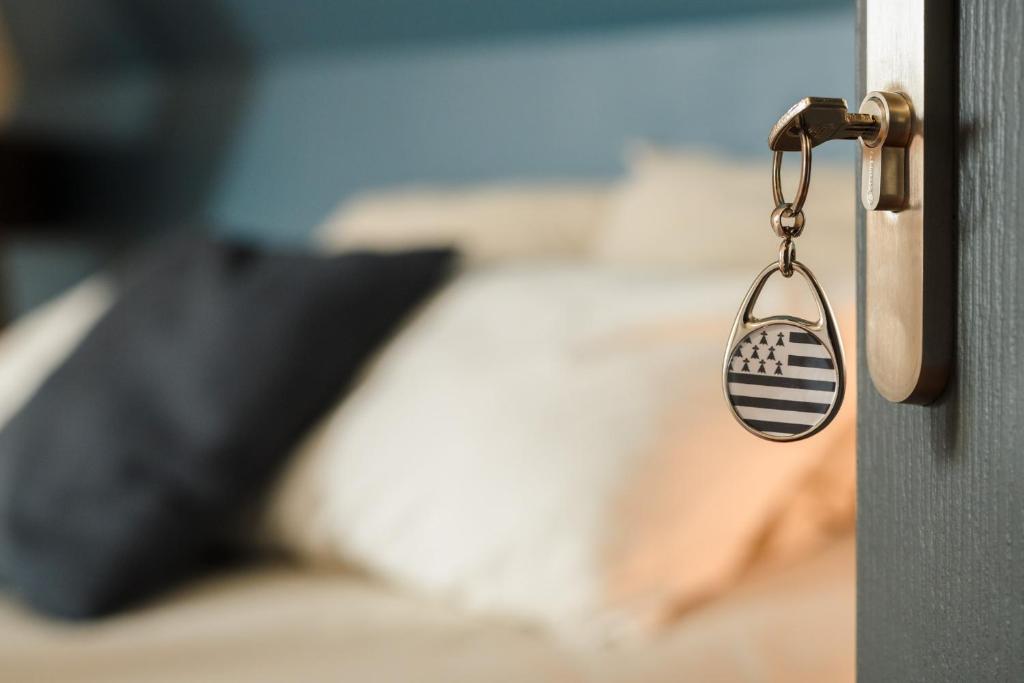 a key to a bedroom door with a pillow at L&#39;Orée du Faubourg - VENDOME CENTRE in Vendôme