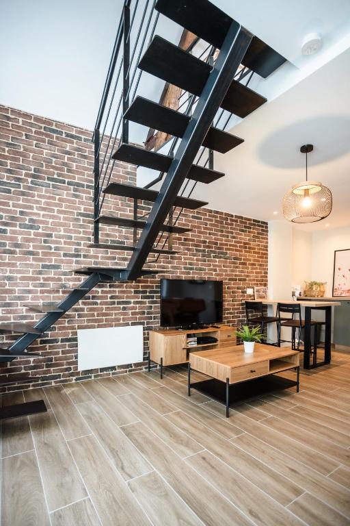 a living room with a staircase and a brick wall at L&#39;Orée du Faubourg - VENDOME CENTRE in Vendôme