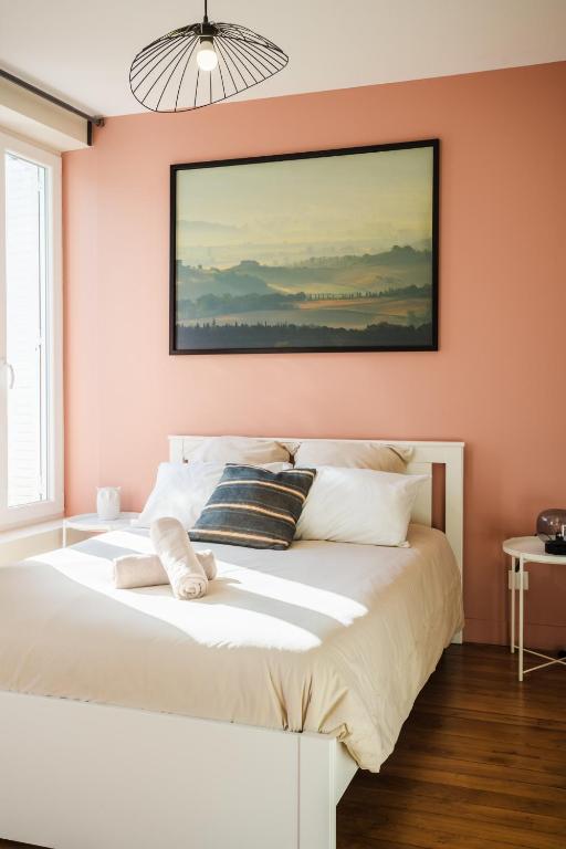 a bedroom with pink walls and a white bed at L&#39;Orée du Faubourg - VENDOME CENTRE in Vendôme