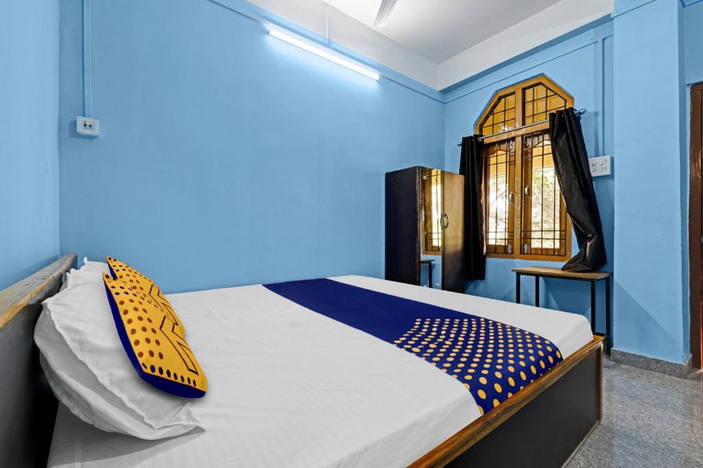 Schlafzimmer mit einem Bett mit blauen Wänden und einem Fenster in der Unterkunft OYO Hotel Garam Masala Residency in Guwahati