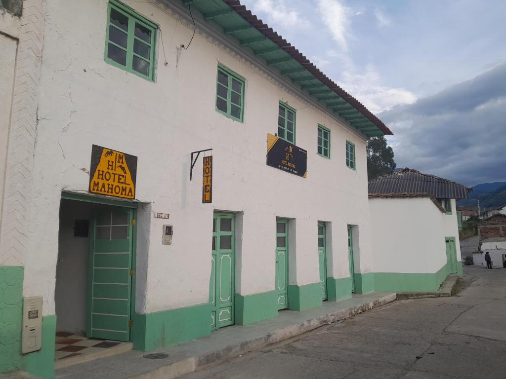 un edificio blanco y verde con un cartel en él en Hotel Mahoma, en El Cocuy