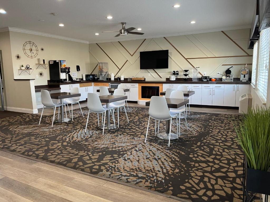 una cocina con sillas y mesas blancas y una encimera en BridgePointe Advantage by BPhotels, en Fremont