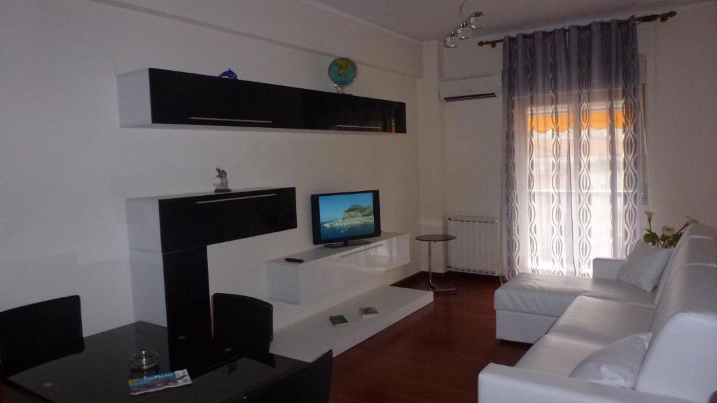 a living room with a white couch and a tv at Sea Star in Cefalù