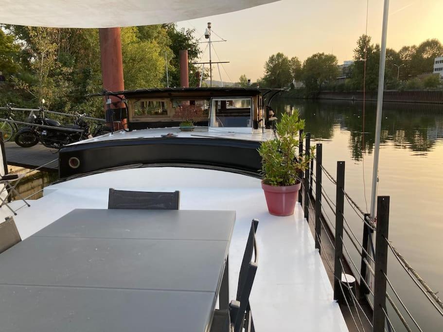 un bateau amarré à un quai avec une table dans l'établissement Péniche au calme sur la Seine, à Rueil-Malmaison