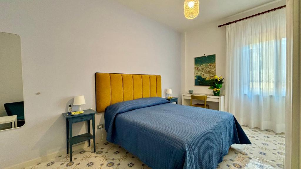 a bedroom with a blue bed and a window at BlueMaGi in Sorrento
