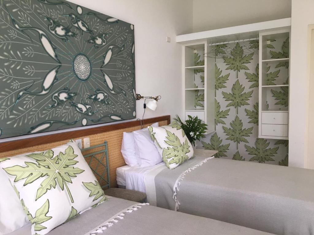 ein Schlafzimmer mit 2 Betten und einem Blumenbild an der Wand in der Unterkunft Papaya Casita - On an organic farm in Jamao al Norte