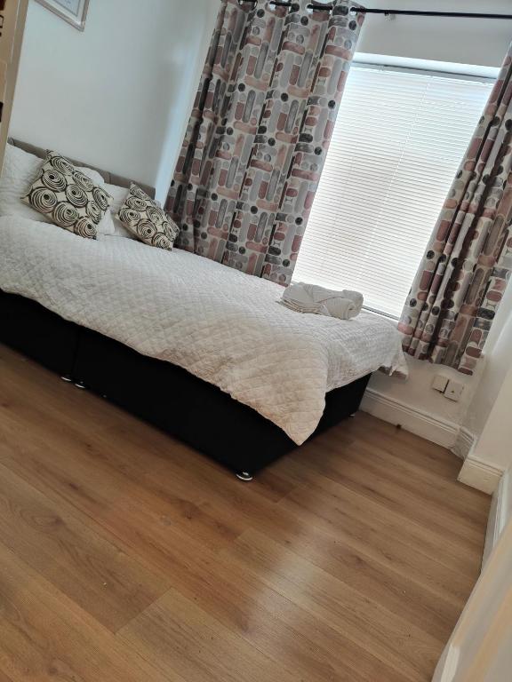 a bedroom with a bed with a window and wooden floors at Rose Apartment in Gortlee