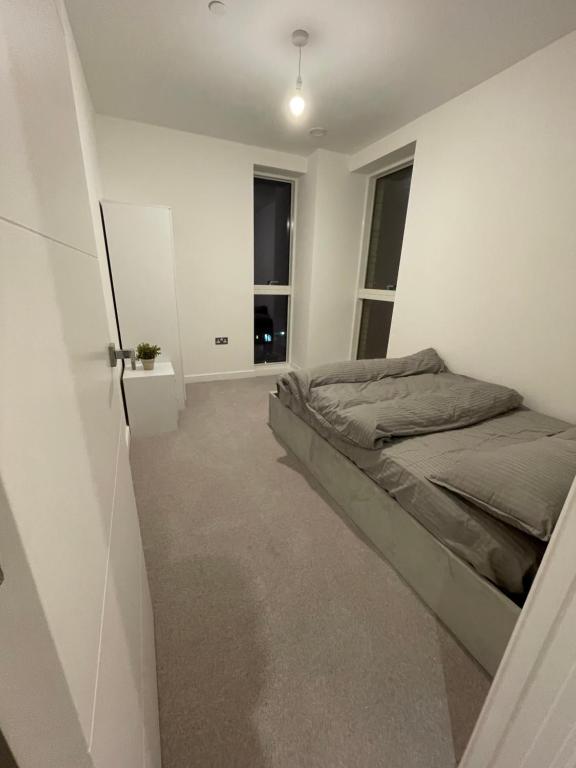 1 dormitorio con 1 cama y un pasillo con ventanas en West Heights SE en Croydon