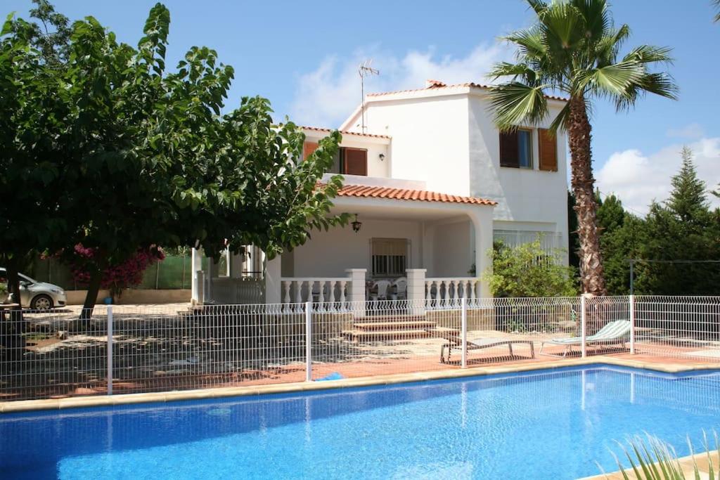 a villa with a swimming pool in front of a house at Chalet in PEÑISCOLA in Peñíscola