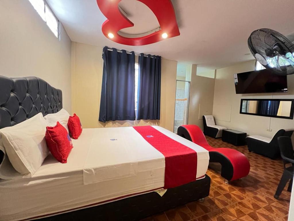 ピウラにあるHospedaje zafiroのベッドルーム1室(大型ベッド1台、赤い枕付)
