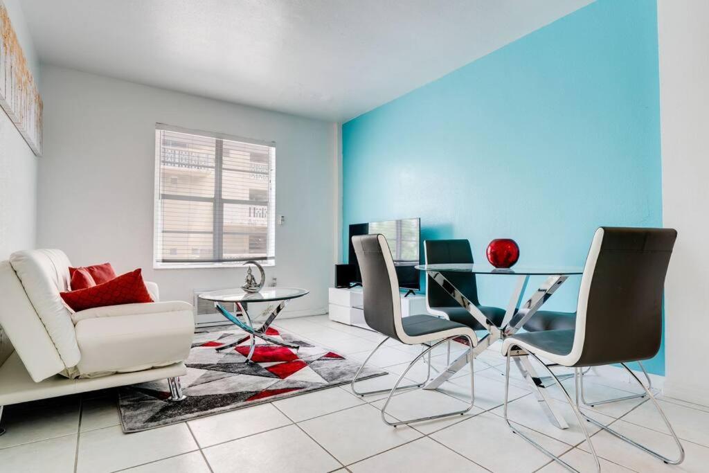 - un salon avec une table et des chaises en verre dans l'établissement Amazing apartment in Miami Beach, à Miami Beach