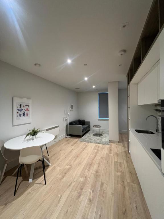 a living room with a white table and a couch at London Heathrow Airport Apartment Voyager House Terminal 12345 - EV Electric and Parking available! in New Bedfont