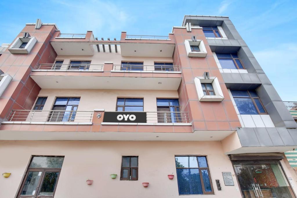 un edificio de apartamentos con una señal omega en él en OYO Flagship Hotel Vivek Plaza en Ambāla