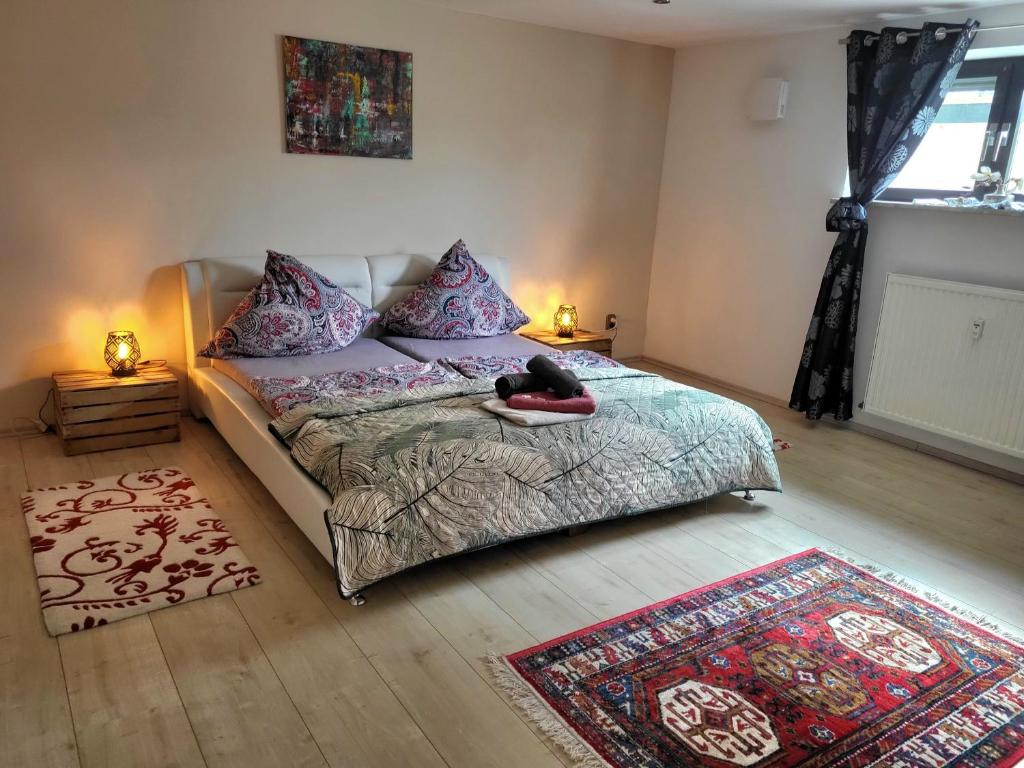 um quarto com uma cama com um gato deitado sobre ela em Mandelas Cozy Lounge em Schmelz