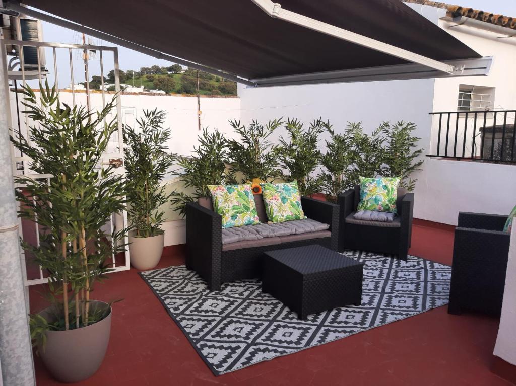 eine Terrasse mit 2 Stühlen und Topfpflanzen in der Unterkunft Aires de Grazalema in Prado del Rey
