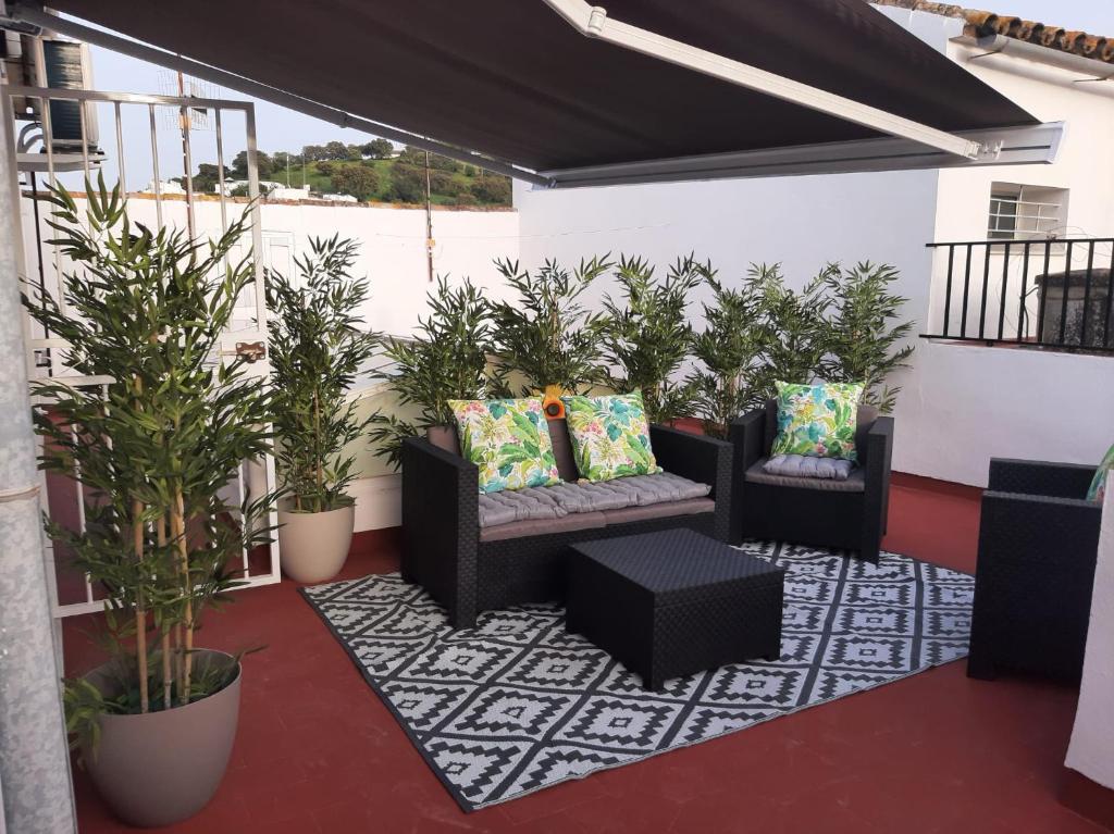 a patio with two chairs and potted plants at Aires de Grazalema in Prado del Rey