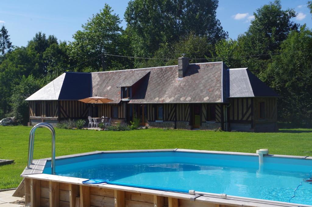 una gran piscina frente a una casa en Ndila Cottage avec piscine exclusive, en Fatouville-Grestain