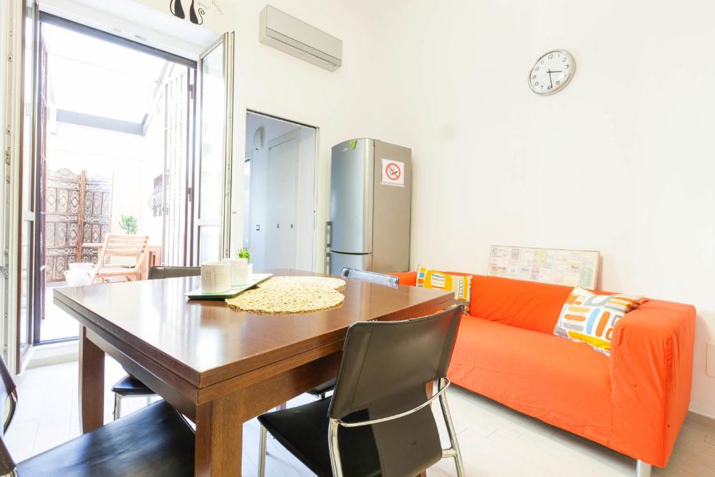 sala de estar con mesa y sofá naranja en Semplicemente Casa, en Milán