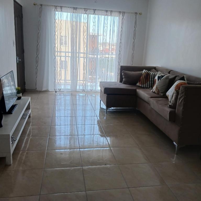 a living room with a couch and a tile floor at Ocean Breeze Apartment in La Romana in La Romana