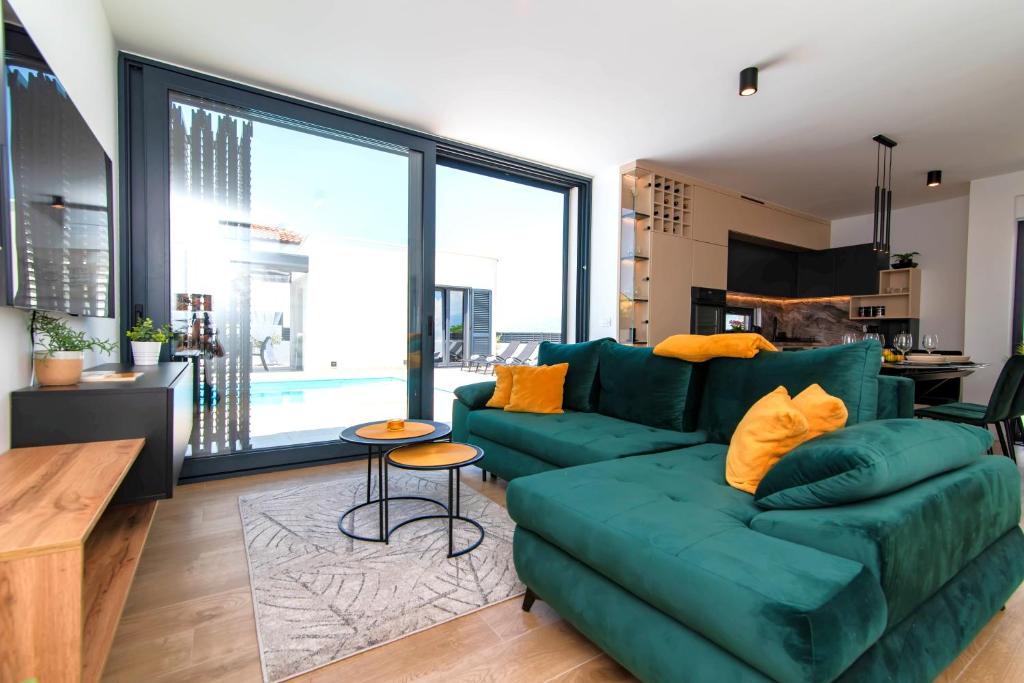 salon z zieloną kanapą i dużym oknem w obiekcie Designer Villa Neva With Magic Velebit View w Ražancu
