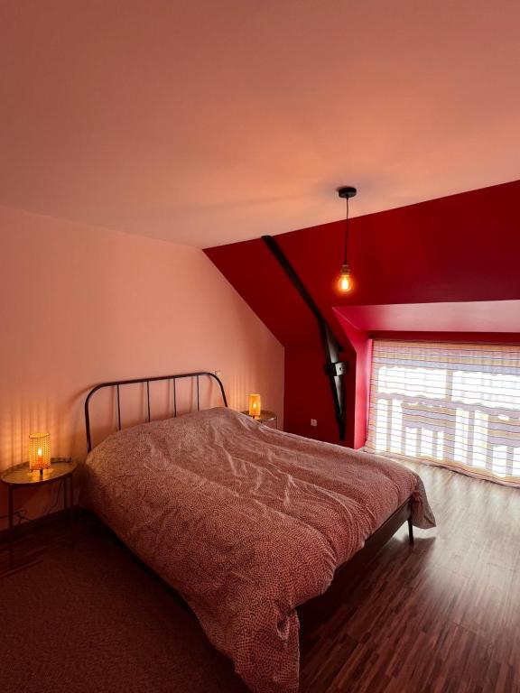 - une chambre avec un lit et un mur rouge dans l'établissement GITES au calme, à Soudan