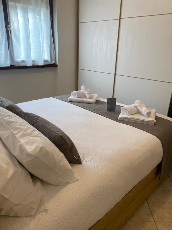 2 Betten in einem Schlafzimmer mit weißer Bettwäsche und Kissen in der Unterkunft Casa Oasi in Seriate