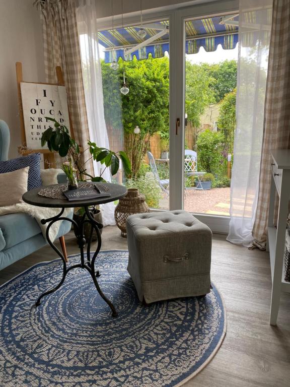 a living room with a table and a ottoman at Ferienwohnung Elisabeth in Blankenhain