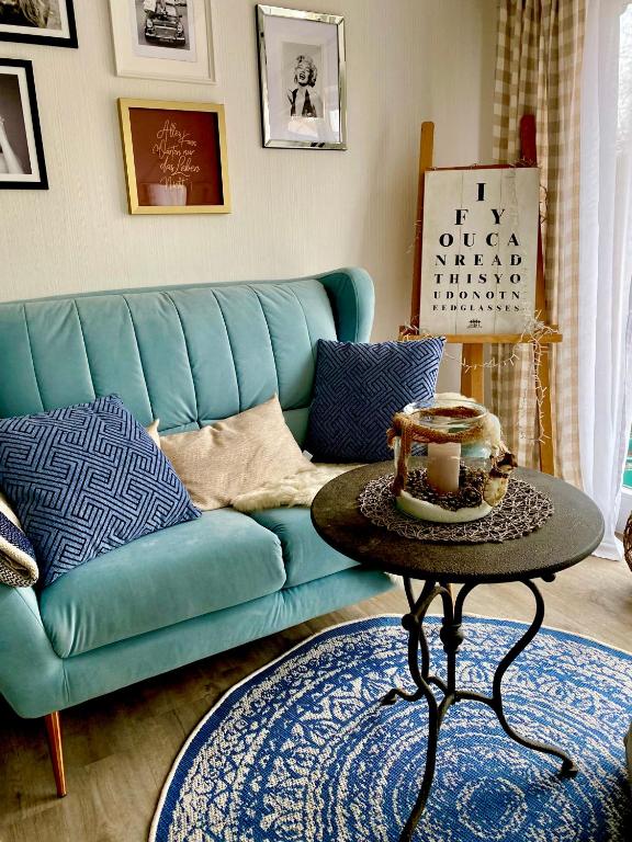 a living room with a blue couch and a table at Ferienwohnung Elisabeth in Blankenhain