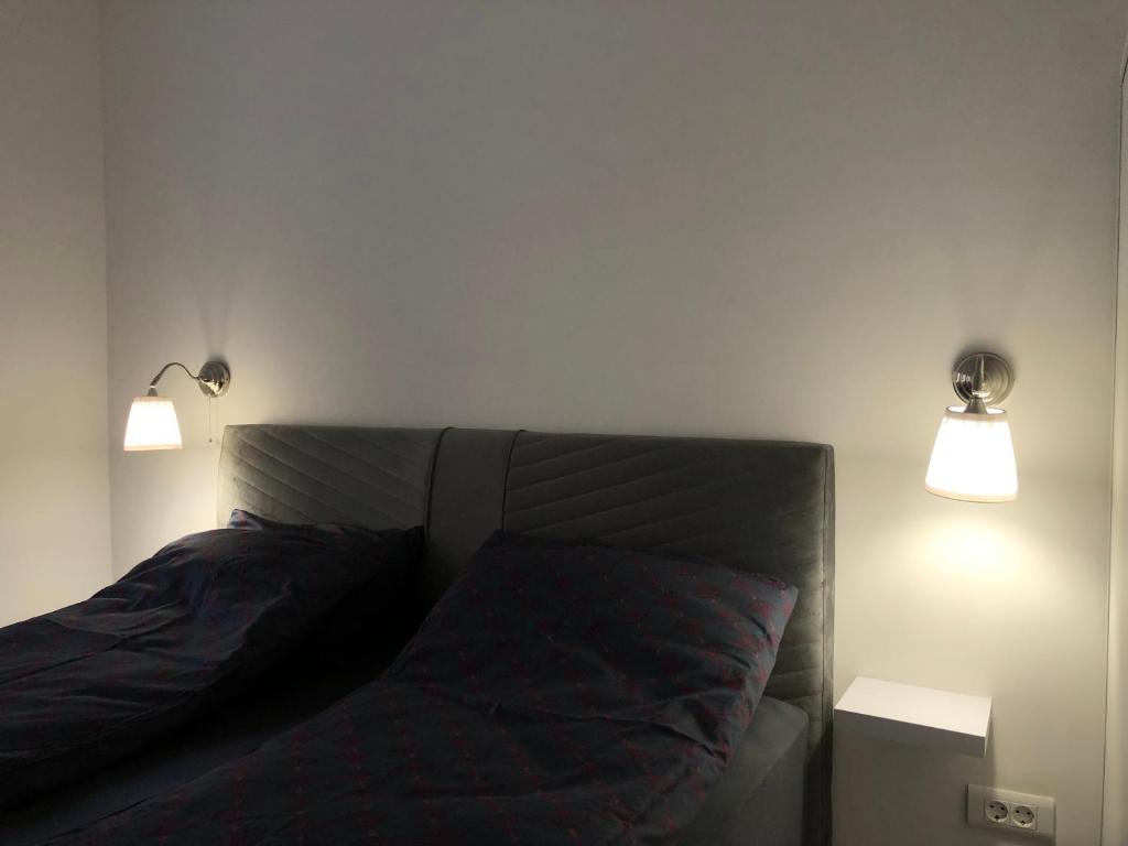 a bedroom with a bed with two lights above it at Centar City Sarajevo Apartman in Sarajevo