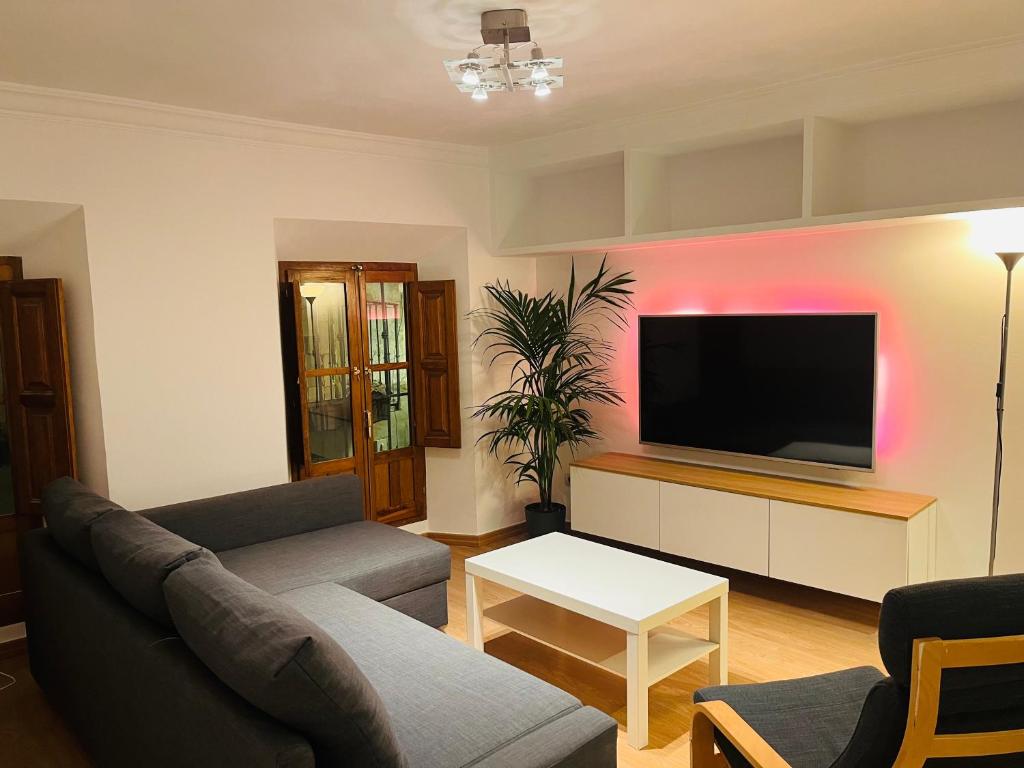 sala de estar con sofá y TV de pantalla plana en ILBIRA, en Granada