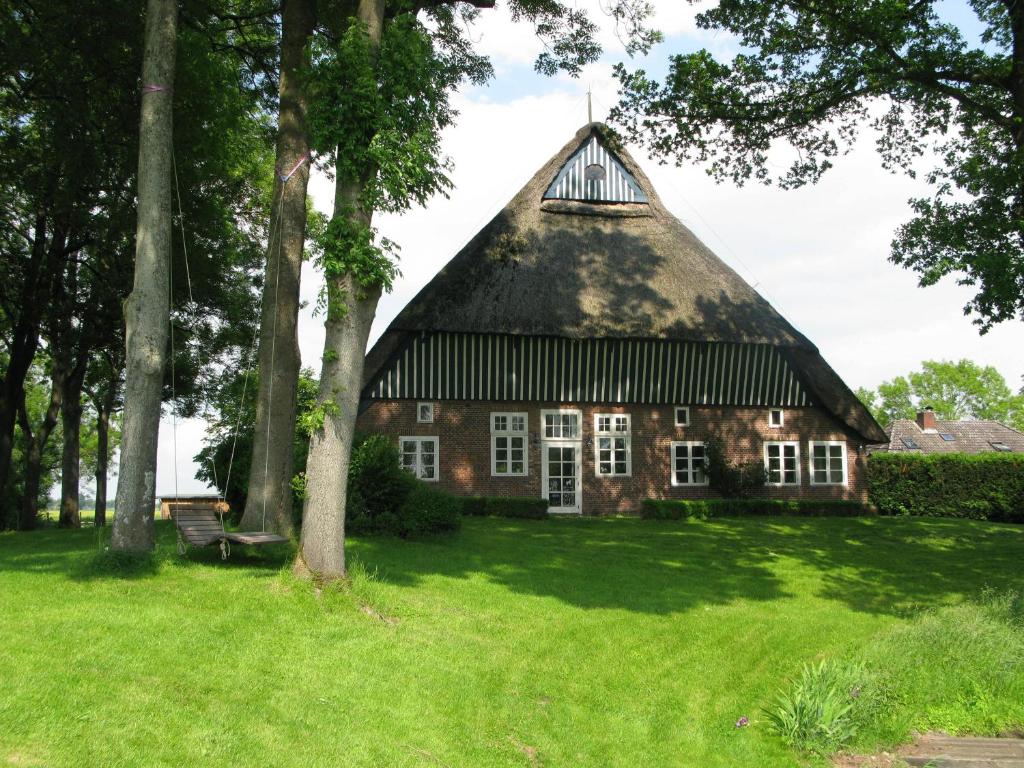 een oud huis met een rieten dak in een veld bij Bielenberg 37 in Kollmar