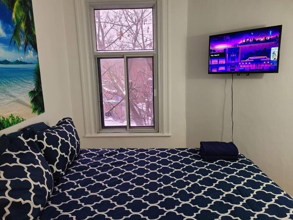 um quarto com uma cama e uma televisão de ecrã plano em Private Parking III Full Kitchen III Room B em Montréal