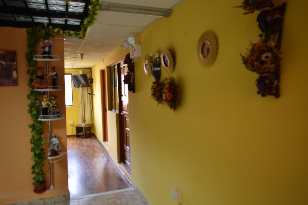a hallway with a yellow wall with decorations on it at Saga Andina II in Cusco