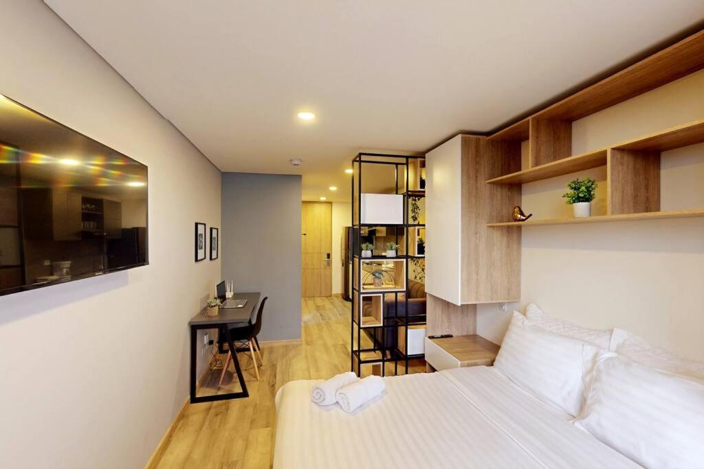 um quarto com uma cama e uma secretária num quarto em Bohemio Luxury Loft Zona T em Bogotá