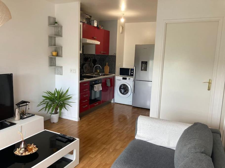 un salon avec un canapé et une cuisine dans l'établissement Appartement T2 Cozy avec Parking, à Argenteuil