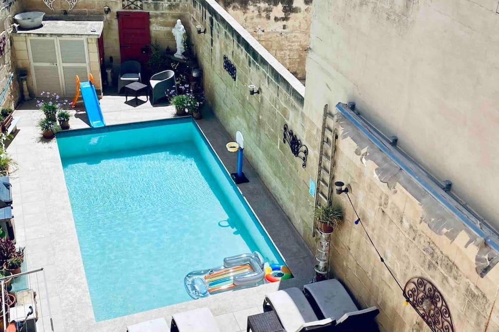 eine Aussicht auf den Pool eines Gebäudes in der Unterkunft Free Breakfast, Pool, Spacious Aircon Hideaway in Mosta
