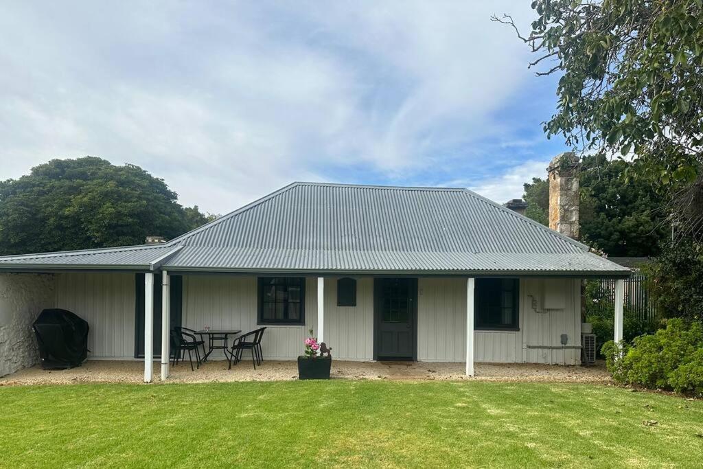 a white house with a table and chairs in a yard at Ulva Cottage - Historical BnB in Penola