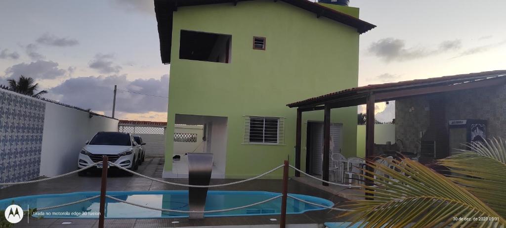 un edificio con piscina di fronte a una casa di Casa veraneio a Itamaracá