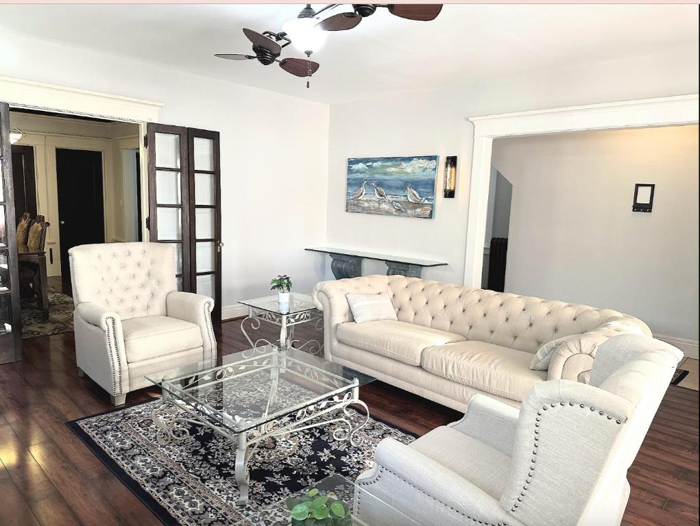 uma sala de estar com um sofá e duas cadeiras e uma mesa em Elmwood village home em Buffalo