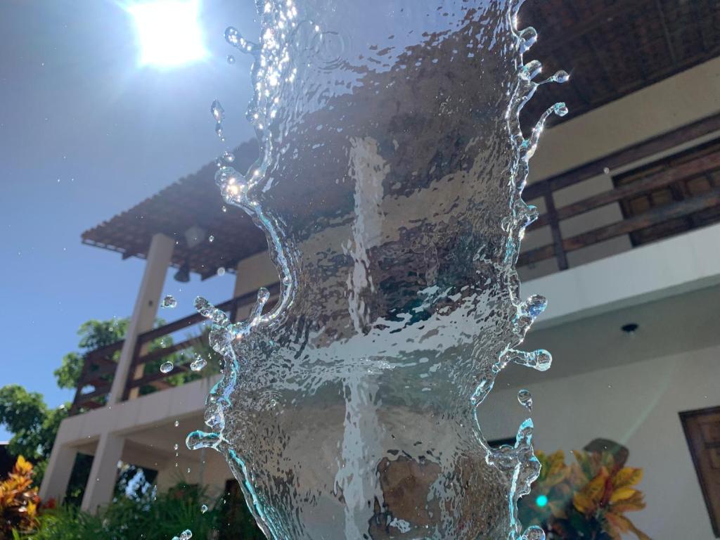 a water fountain in front of a building at Casa no francês! in Marechal Deodoro