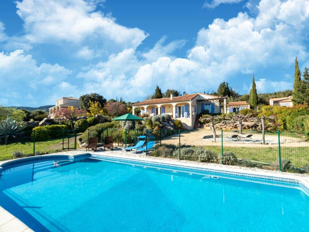 une grande piscine en face d'une maison dans l'établissement Tranquil holiday home with private pool, à Félines-Minervois